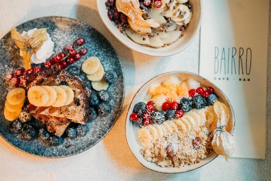 Frühstücksteller mit French Toast, Beeren und Bowl, daneben die Bairro-Karte